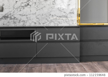 Black wooden cabinet with marble walls 112159648