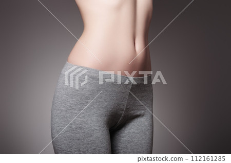 Beautiful young woman dressed in a gray sports Beautiful young woman dressed in a gray sports 112161285