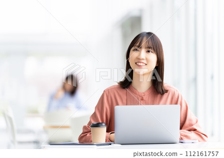 Smiling business woman using a laptop 112161757