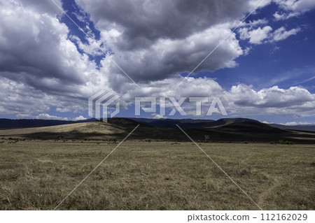 Tanzania, Ngorongoro, crater landscape with beautiful clouds on blue sky background 112162029