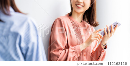 Smiling business woman using a smartphone Smiling business woman using a smartphone 112162116