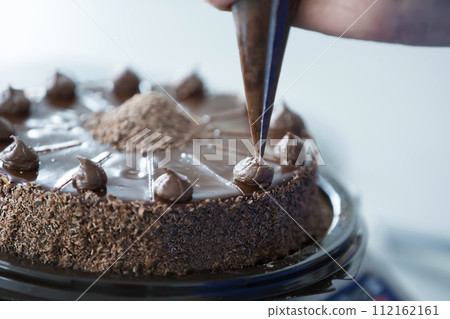 Decorate chocolate cake with cream 112162161