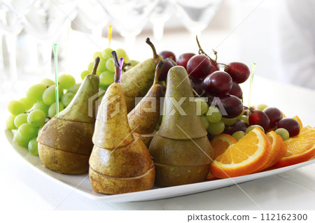 On a plate of pears, grapes, oranges On a plate of pears, grapes, oranges 112162300
