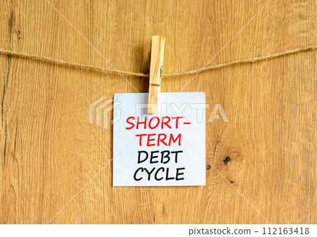Short-term debt cycle symbol. Concept words Short-term debt cycle on beautiful white paper on clothespin. Beautiful wooden background. Business Short-term debt cycle concept. Copy space 112163418