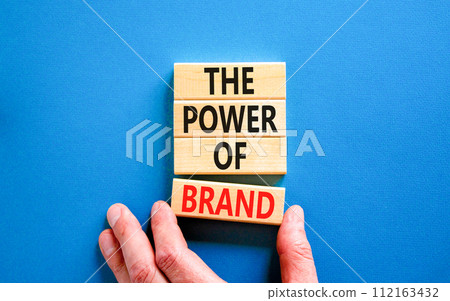 The power of brand symbol. Concept words The power of brand on beautiful wooden block. Beautiful blue table blue background. Businessman hand. Business the power of brand concept. Copy space. The power of brand symbol. Concept words The power of brand on beautiful wooden block. Beautiful blue table blue background. Businessman hand. Business the power of brand concept. Copy space. 112163432