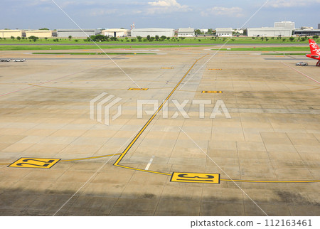Aerial view of a commercial airport runway with marking on taxiway. Aerial view of a commercial airport runway with marking on taxiway. 112163461