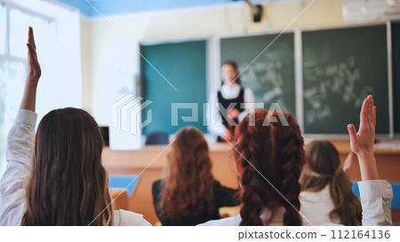 Girl students raise their hands in math class. 112164136