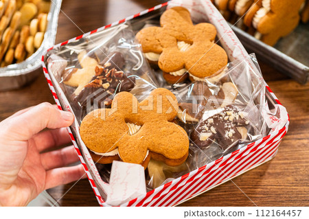 Lovingly homemade gingerbread and sugar cookies, half-dipped in rich chocolate, nestled in decorative Christmas tin boxes perfect for seasonal gifting. 112164457
