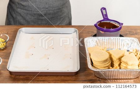 Golden-hued cookies shaped like snowflakes, intricately stacked. 112164573