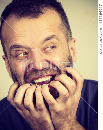 Man biting his nails Man biting his nails 112164997