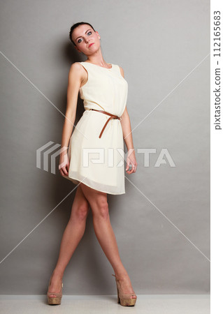 Glamour girl in white dress on gray 112165683