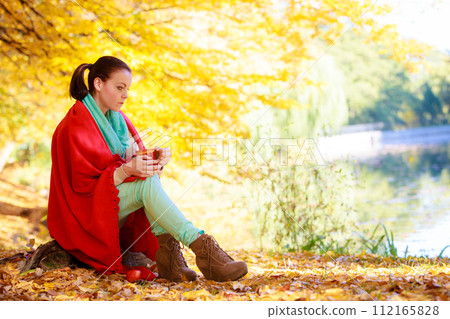 thoughtful girl in the autumn park enjoying hot drink thoughtful girl in the autumn park enjoying hot drink 112165828