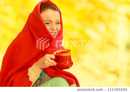 Woman relaxing in park drinking drink from mug 112165830