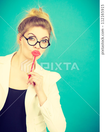 Happy woman holding fake lips on stick Happy woman holding fake lips on stick 112165915