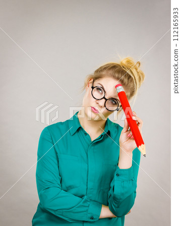 Woman confused thinking, big pencil in hand 112165933