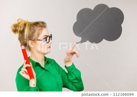 Woman holding big oversized pencil thinking Woman holding big oversized pencil thinking 112166094