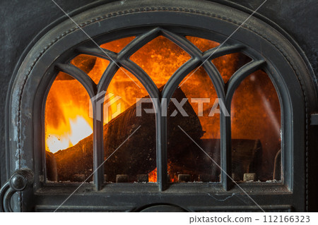 Closeup of burning fire wood in home fireplace. 112166323