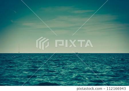 Calm sea water and tower with antennas 112166943