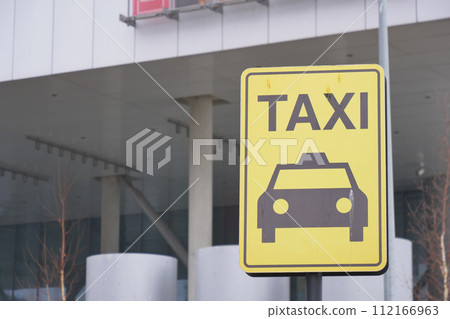 Close-up photo of a yellow Taxi stand sign attached to a metal pole Close-up photo of a yellow Taxi stand sign attached to a metal pole 112166963