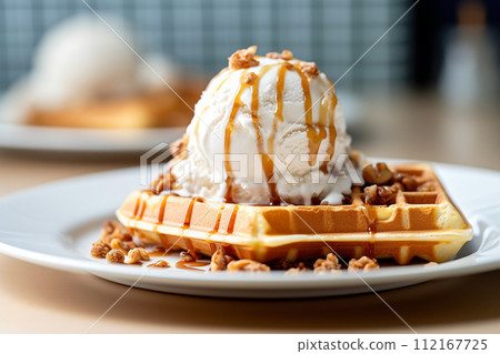 Stack of waffles drizzled with chocolate syrup and strawberries topping with vanilla ice cream 112167725