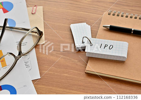 有寫成 IPO、眼鏡和筆的單字書的桌子 112168336