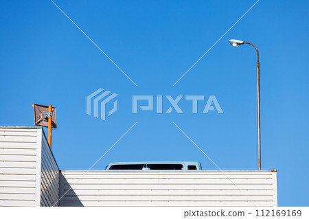 Cars on the rooftop parking lot, street lights, curved mirrors and blue sky Cars on the rooftop parking lot, street lights, curved mirrors and blue sky 112169169