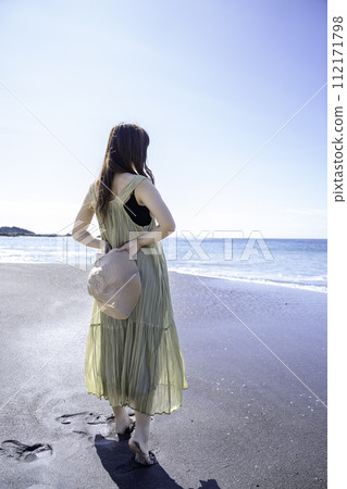 A woman in one piece walking on the sandy beach A woman in one piece walking on the sandy beach 112171798