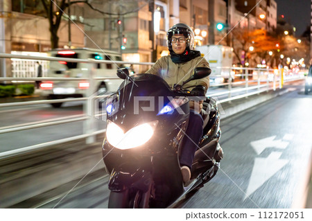 Motorcycle running through the city at night Motorcycle running through the city at night 112172051