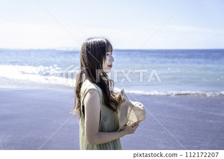 A woman in one piece walking along the coast A woman in one piece walking along the coast 112172207