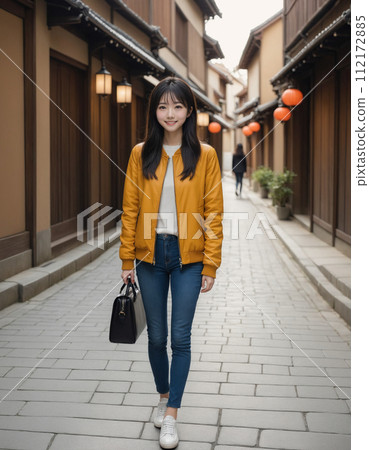 年輕女子穿過一條兩旁都是日本老房子的街道 112172885