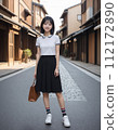 年輕女子穿過一條兩旁都是日本老房子的街道 112172890