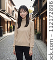 年輕女子穿過一條兩旁都是日本老房子的街道 112172896