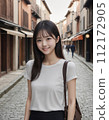 年輕女子穿過一條兩旁都是日本老房子的街道 112172905