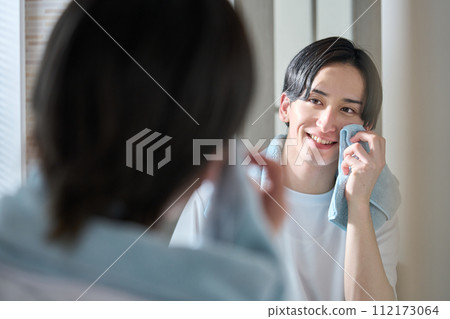 man wiping face with towel 112173064