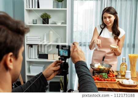 Cameraman recording to woman in chef influencer cooking spaghetti. Postulate. Cameraman recording to woman in chef influencer cooking spaghetti. Postulate. 112173188