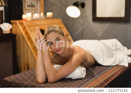Beautiful woman lies on spa bed in front of wooden sauna cabinet. Tranquility. Beautiful woman lies on spa bed in front of wooden sauna cabinet. Tranquility. 112173191