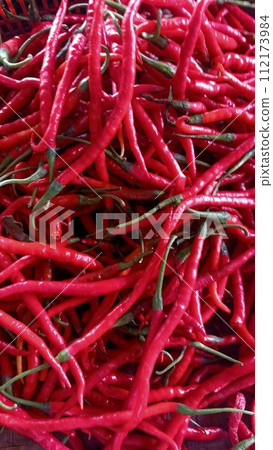 Close up of red curly chili pepper at the market Close up of red curly chili pepper at the market 112173984