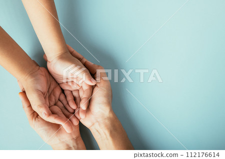 Studio shot, Top view of family hands stacked on isolated background. Parents and kid hold empty space a gesture of support and love for Family and Parents Day. Studio shot, Top view of family hands stacked on isolated background. Parents and kid hold empty space a gesture of support and love for Family and Parents Day. 112176614