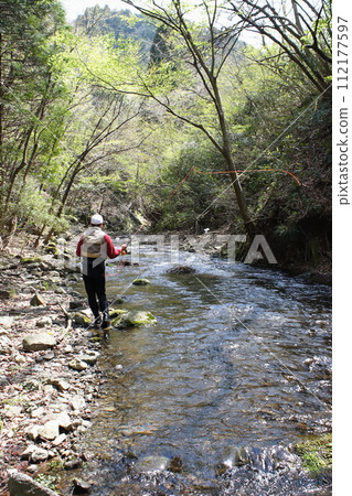 Anglers enjoying fly fishing in a nearby mountain stream Anglers enjoying fly fishing in a nearby mountain stream 112177597