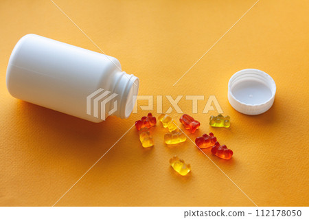 children's jelly vitamins in a bottle on a yellow background 112178050