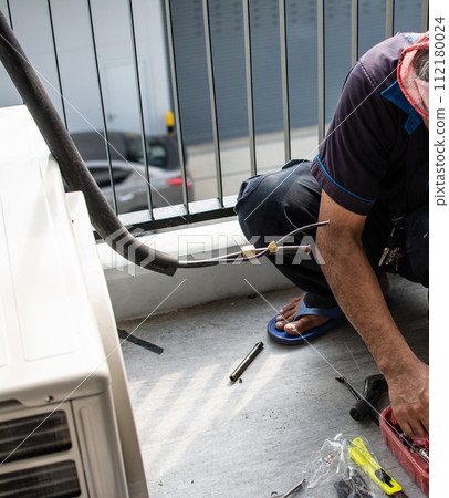 Technician install air conditioner outdoor unit Technician install air conditioner outdoor unit 112180024