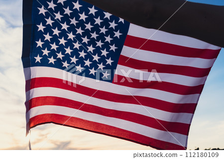 Waving American Flag on sun Background. Flag of the united states of America. July 4th Independence Day. USA patriotism national holiday proud. Waving American Flag on sun Background. Flag of the united states of America. July 4th Independence Day. USA patriotism national holiday proud. 112180109