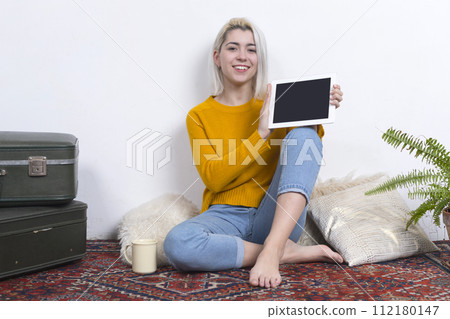 Smiling woman holding a tablet with a blank screen. 112180147