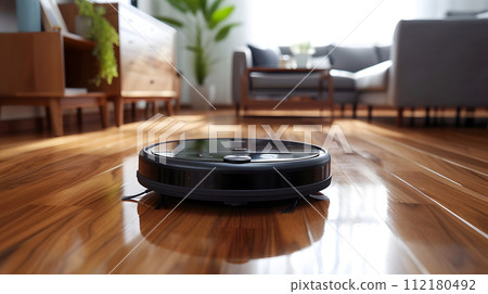 close up of a robotic vacuum glides seamlessly across a polished hardwood floor close up of a robotic vacuum glides seamlessly across a polished hardwood floor 112180492
