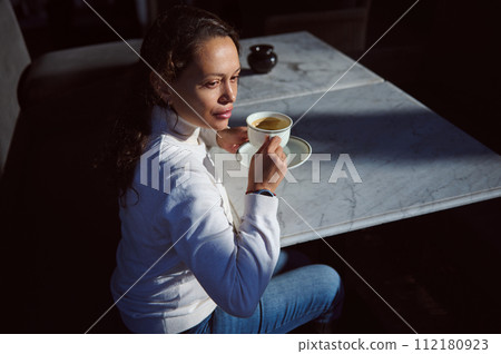 Overhead view of carefree female freelancer, confident business woman sitting at table and drinking coffee Overhead view of carefree female freelancer, confident business woman sitting at table and drinking coffee 112180923