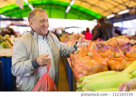 Man purchasing potatoes in greengrocery 112183539