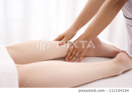 一位女士正在接受美容師的足部按摩 一位女士正在接受美容師的足部按摩 112184184