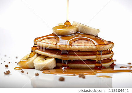 Stack of pancakes with maple syrup and banana slices. 112184441