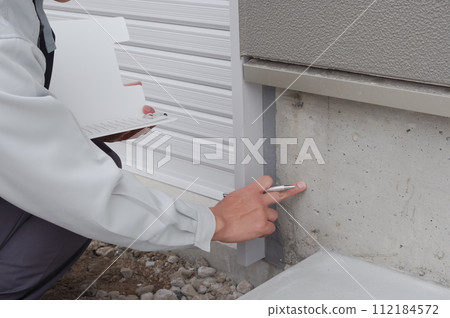 一名男子正在檢查房屋的地基 112184572