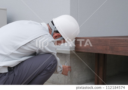 一名男子正在檢查房屋的地基 112184574